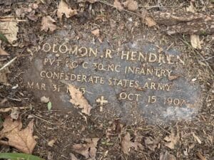 Moss-covered tombstone with engraved text