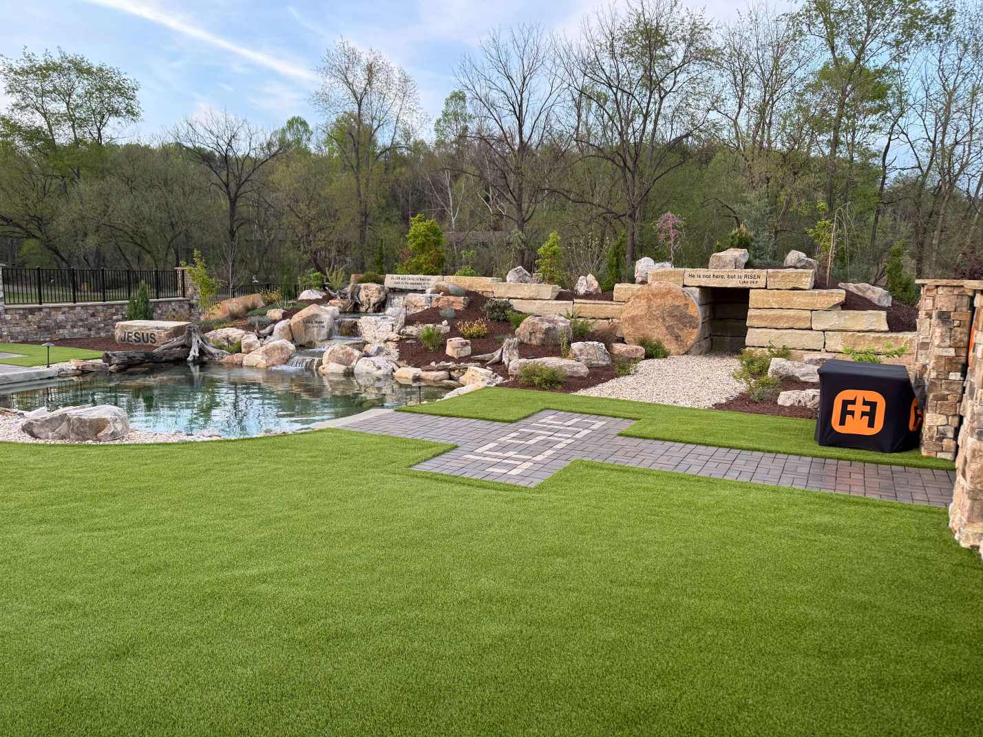 Backyard pond with rock waterfall and stone tomb